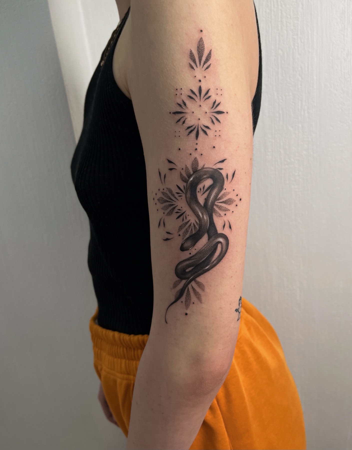 Dotwork-Tattoo einer Schlange mit floralem Mandala